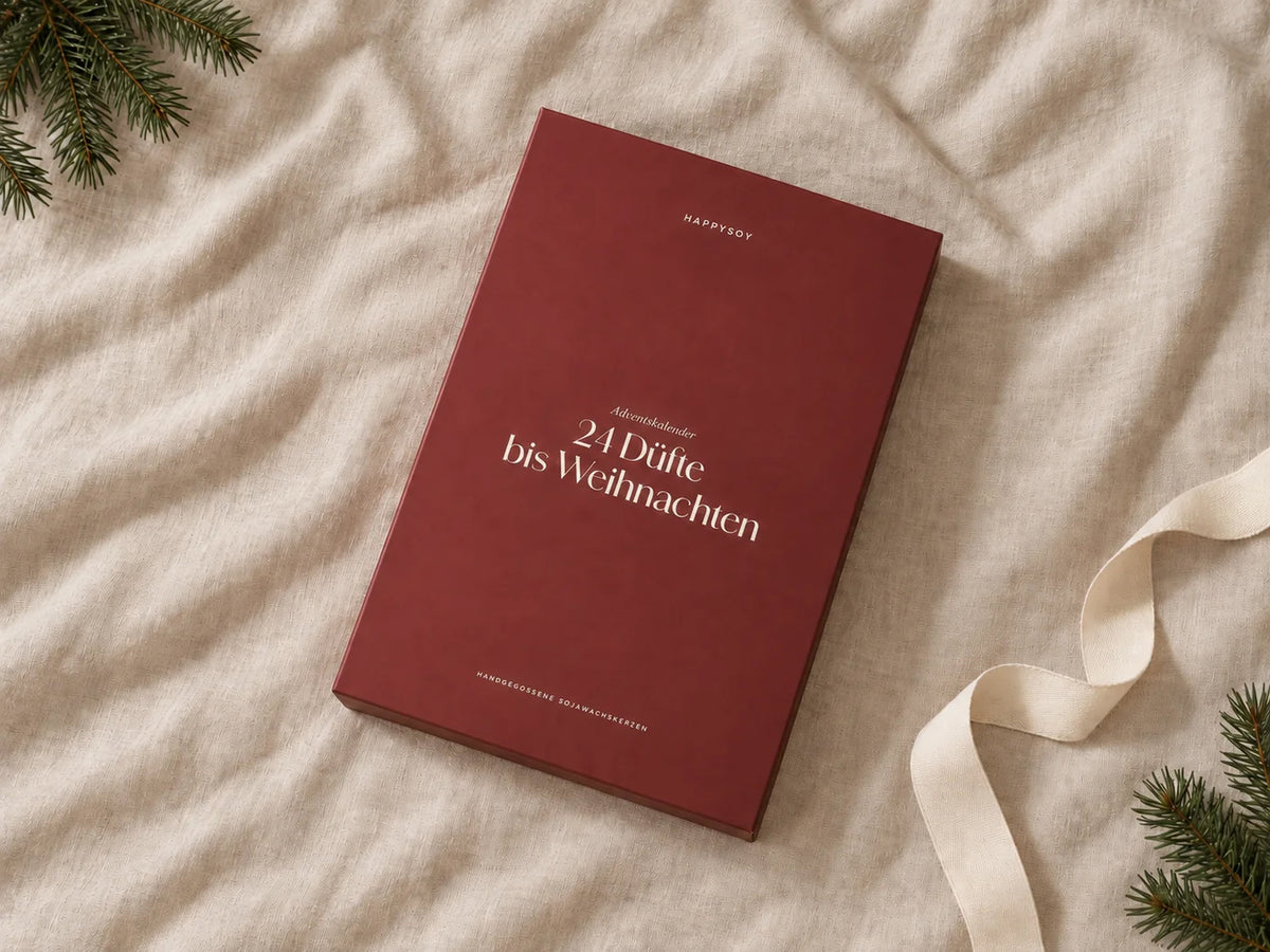 Geschlossener HAPPYSOY Adventskalender in Beerenrot auf hellem Leinen mit Tannenzweigen und Geschenkband
